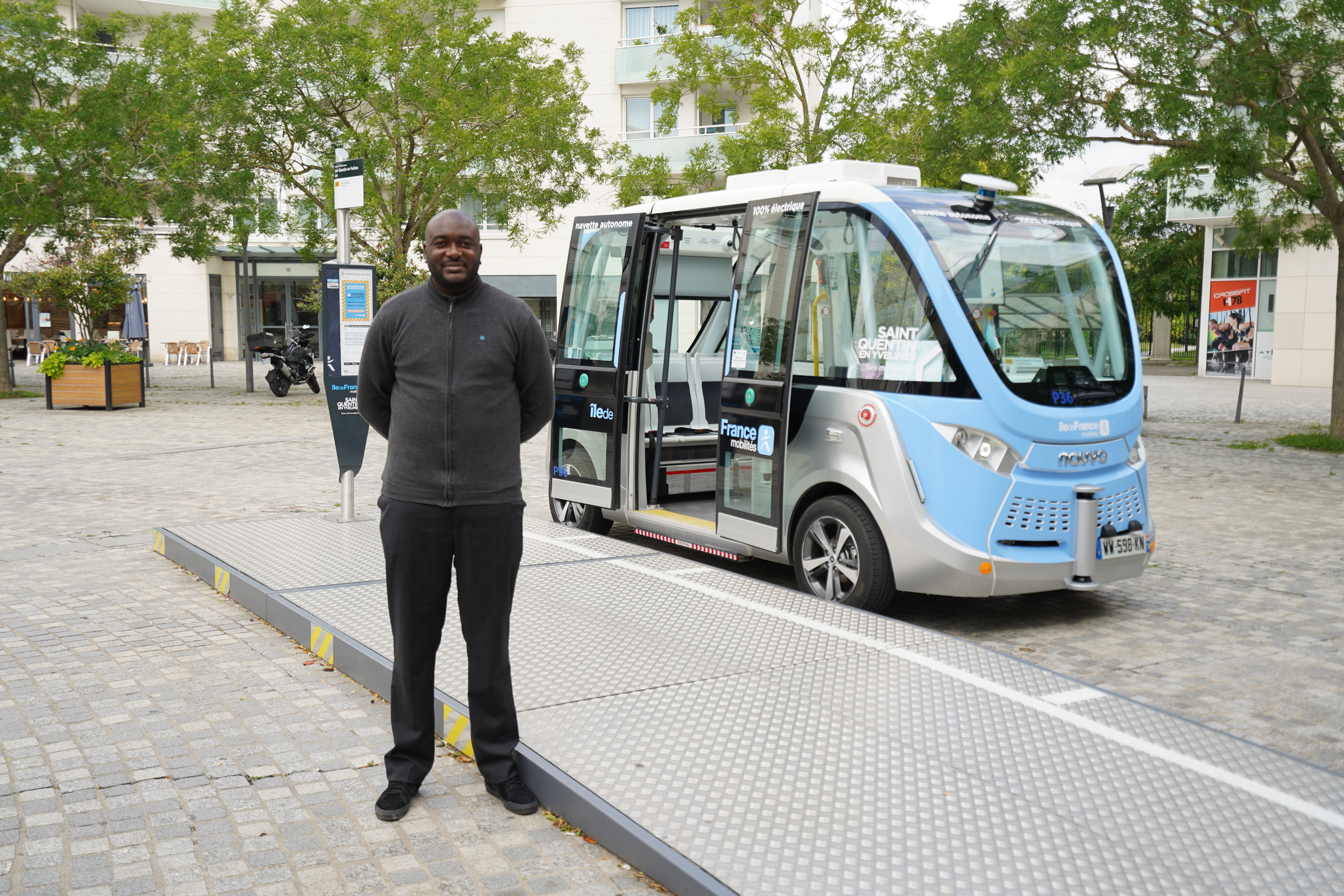 Keolis operator in front of an autonomous shuttle in Saint-Quentin-en-Yvelines