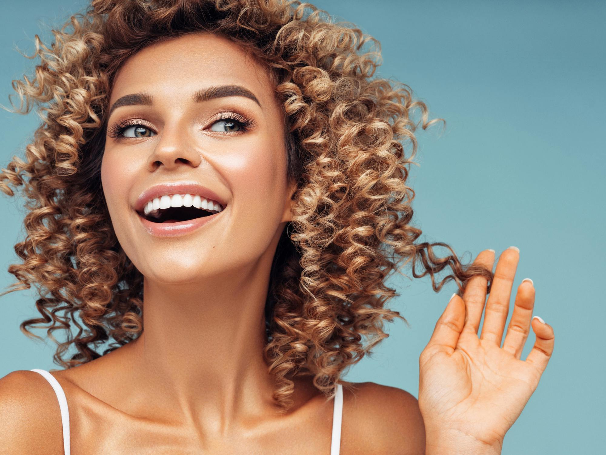 model with curly hair smiling