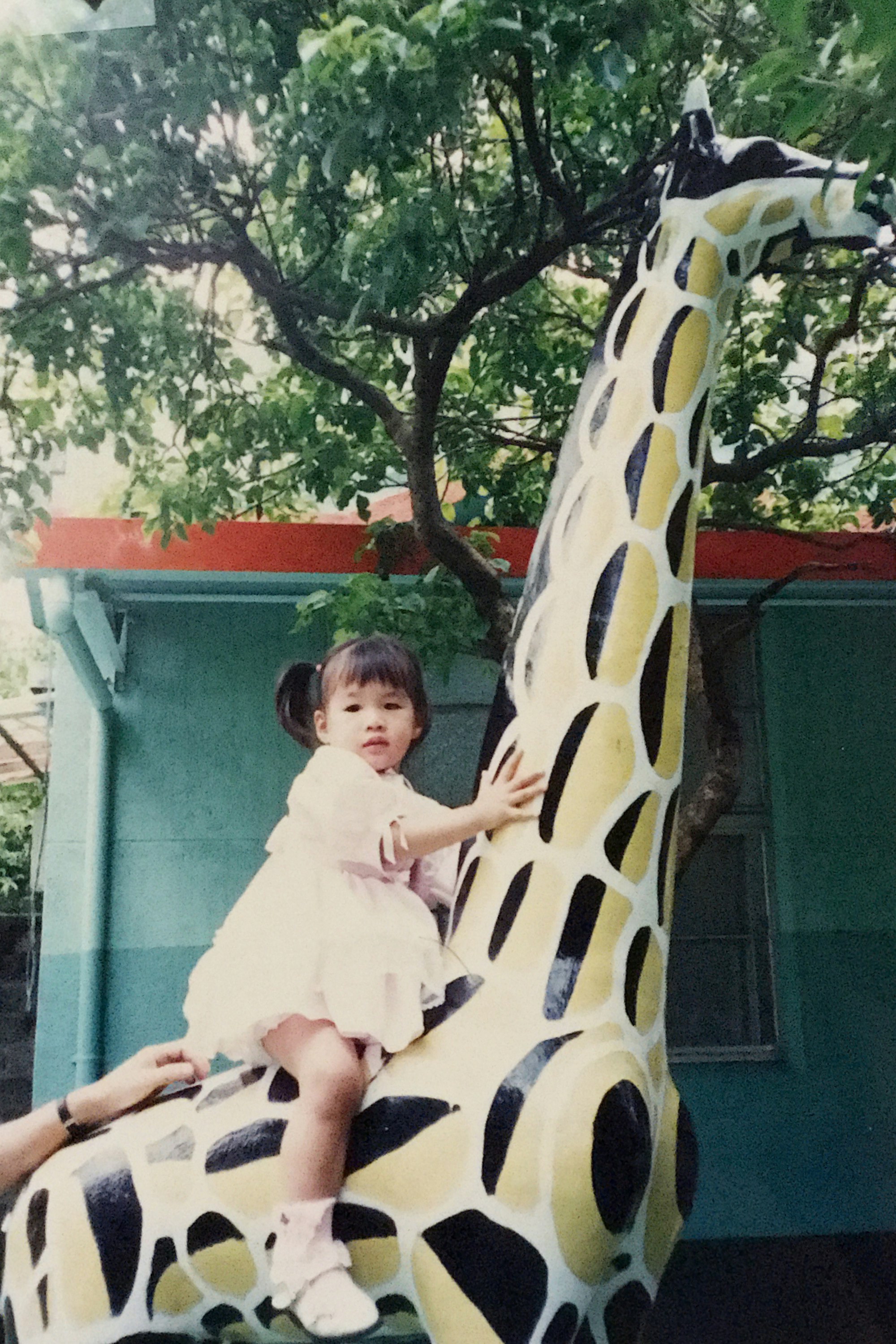 Li as a child on a large plastic giraffe in a local park, Taipei, Taiwan. 1994.