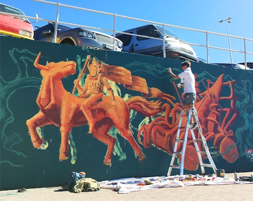 Rel painting a mural for the Bondi Beach Sea Wall in 2018