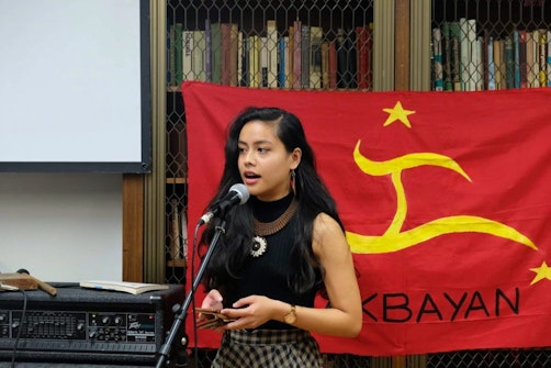 Eunice Andrada reads her poems at Anakbayan’s community fundraiser for the families of farmers murdered by the Philippine military, 2019; photo: Bryle Leaño