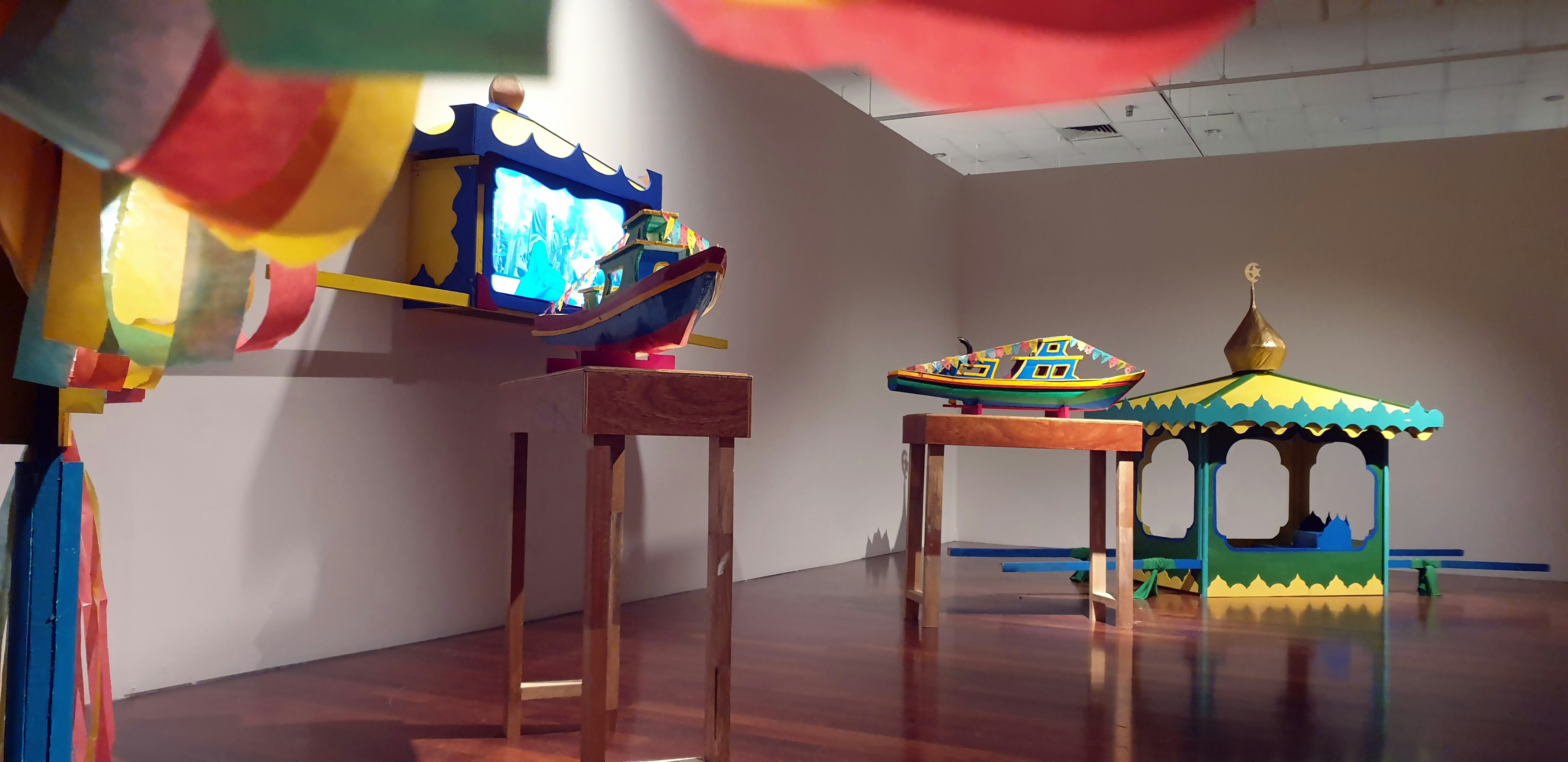 Colourful and wooden structures placed in a gallery.