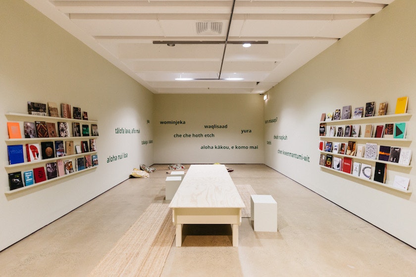The interior of an art gallery reading room, with shelves of books on the left and right walls.