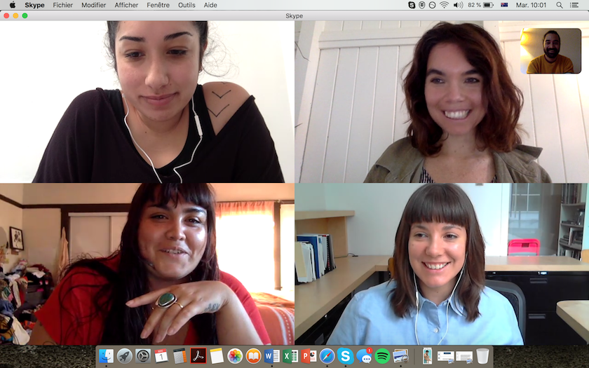 Four female-presenting curators on a video call, from top left: a person with tanned skin, black hair pulled up into a bun and a black top that shows a tattoo on their left shoulder; a smiling person with shoulder-length wavy hair and a khaki green jacket; a smiling person with brown shoulder-length hair and bangs, wearing a blue button up blouse; a person with long brown hair and bangs, wearing a red top and a green stone ring on their left hand.