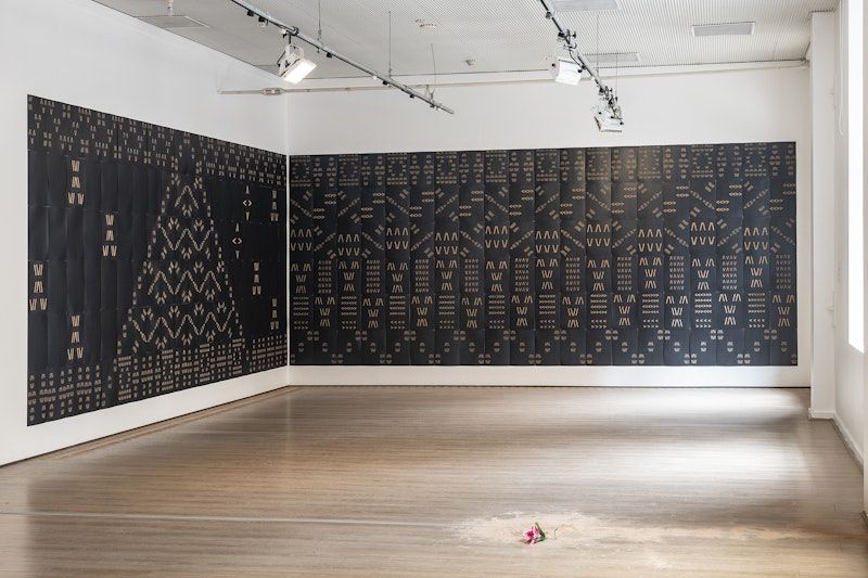 Back left:  Vaimaila Urale, Manamea ma Anivanuanua, 2020, black card and sand, 240 pieces across two walls, each wall installation measuring 5940x2520mm. Front right:  Terry Faleono, Sand, 2020, sand and plastic flower, dimensions variable. Photo: Kai Wasikowski for 4A Centre for Contemporary Asian Art. Courtesy the artist.