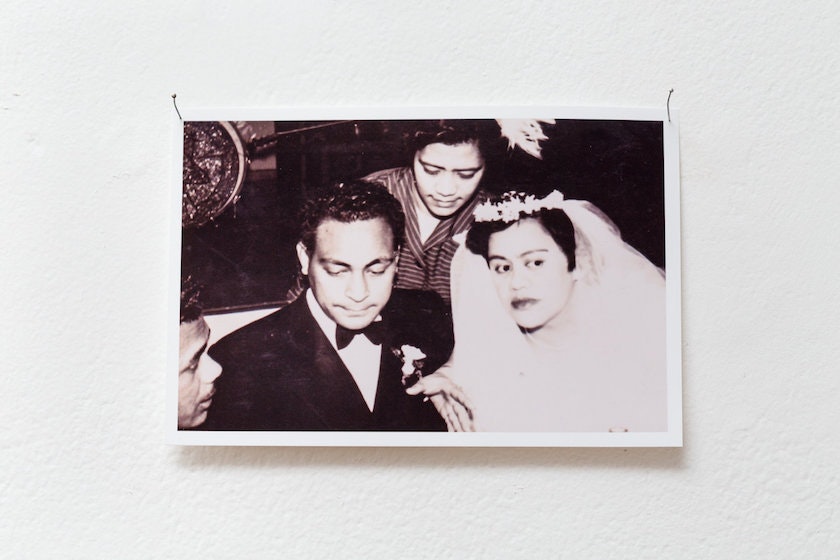 Photograph of a black and white photo, depicting a bride in a veil and a groom.