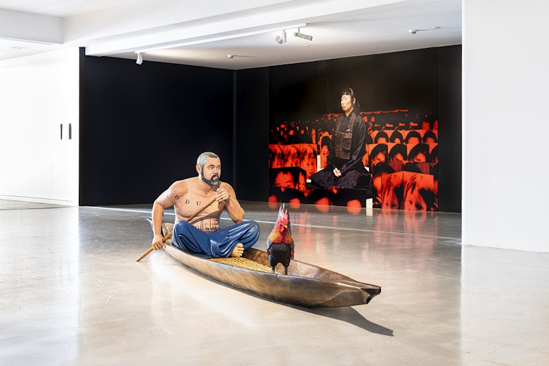 Front: Abdul-Rahman Abdullah, Merantau, 2016, carved and stained wood; commissioned by Art Gallery of South Australia; photo: Kai Wasikowski for 4A Centre for Contemporary Asian Art | Back: Robert Scott-Mitchell, Birth and Death, 2003, inkjet print and synthetic polymer paint on Chinese accordion books, variable dimensions | Photos: Kai Wasikowski for 4A Centre for Contemporary Asian Art; I am heart beating in the world: Diaspora Pavilion 2, Campbelltown Arts Centre; courtesy the artists.