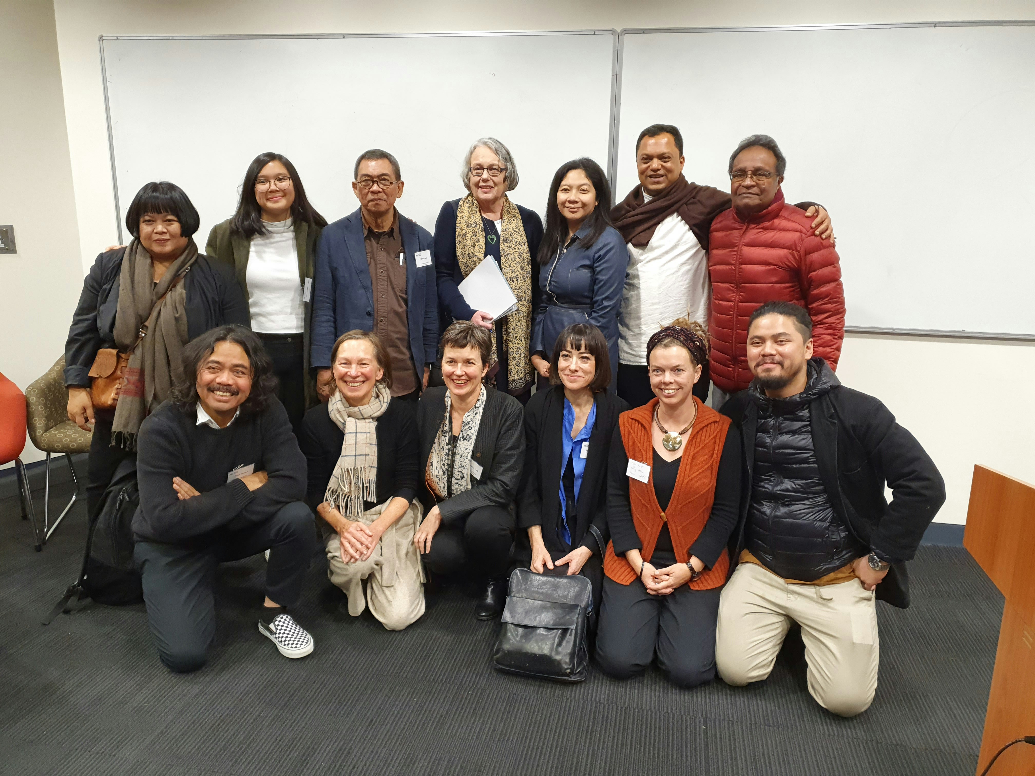 A group of people smiling at a conference.