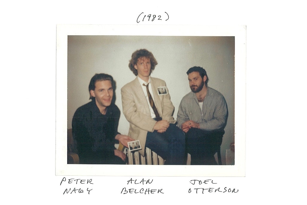 A Polaroid photo of three male-presenting figures sitting against a wall. 