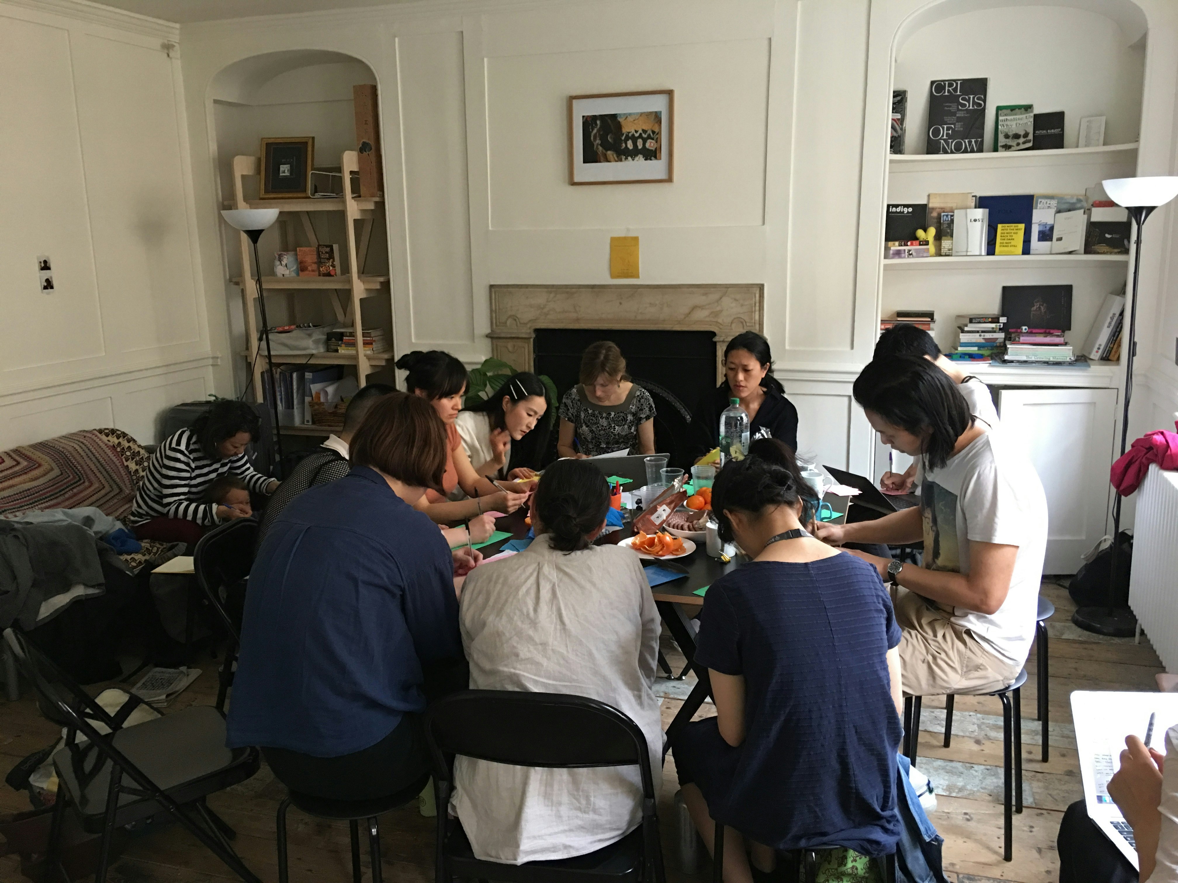 A group of artists of Asian descent seated around a table. 