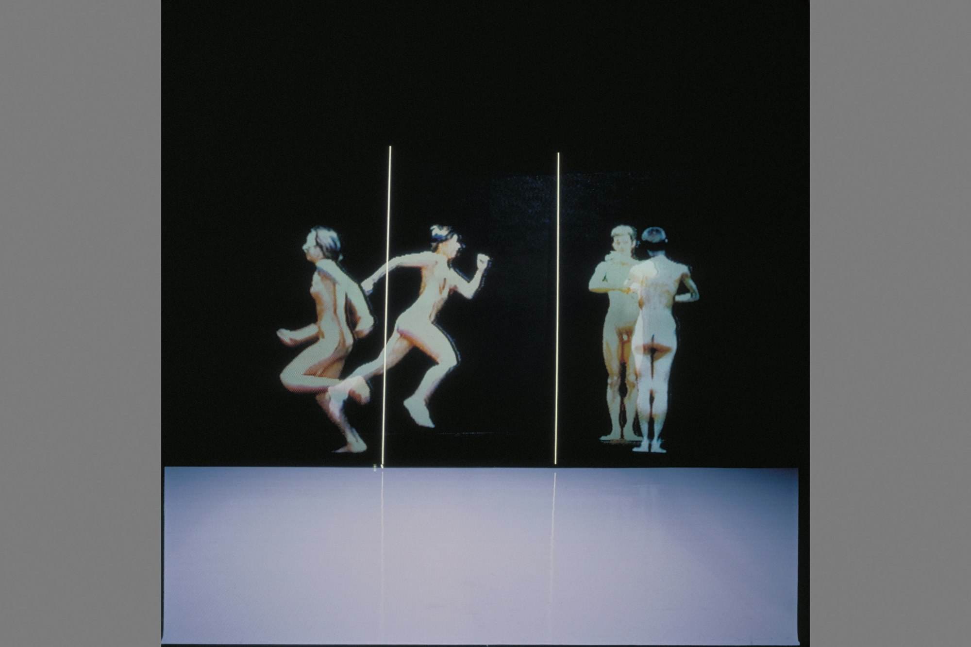 A still of four unclothed bodies: two running away from each other, two facing each other.
