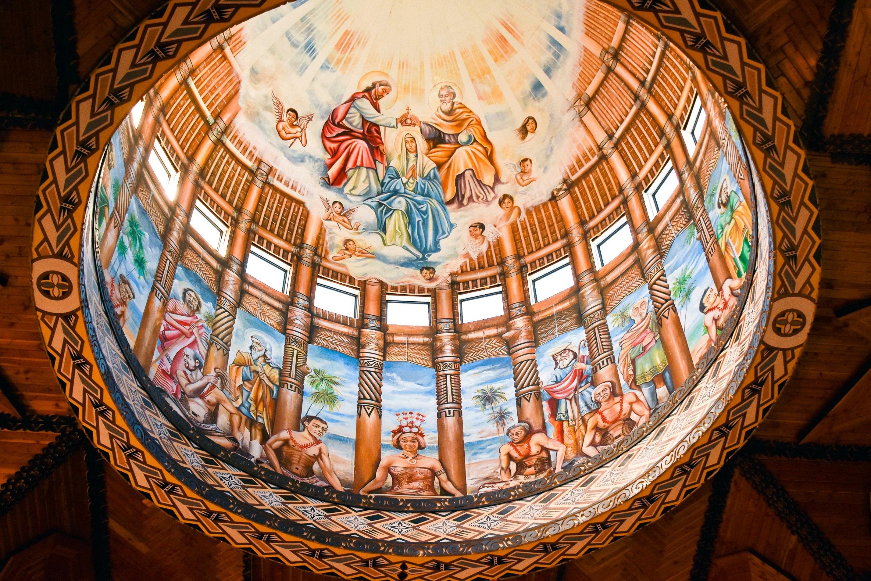 A rounded dome painted with religious Christian imagery with Pasifika elements, such as Samoan patterns on colonnades surrounding apostles sitting at a long dining table. Above them is a triumvirate of Jesus, Mary and Joseph, surrounded by light and cherubin.