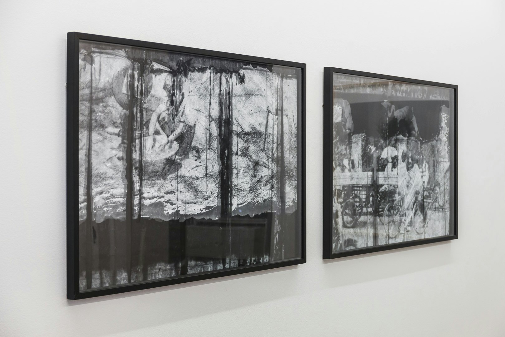 Framed black and white photographic prints of an artist working over a bucket.