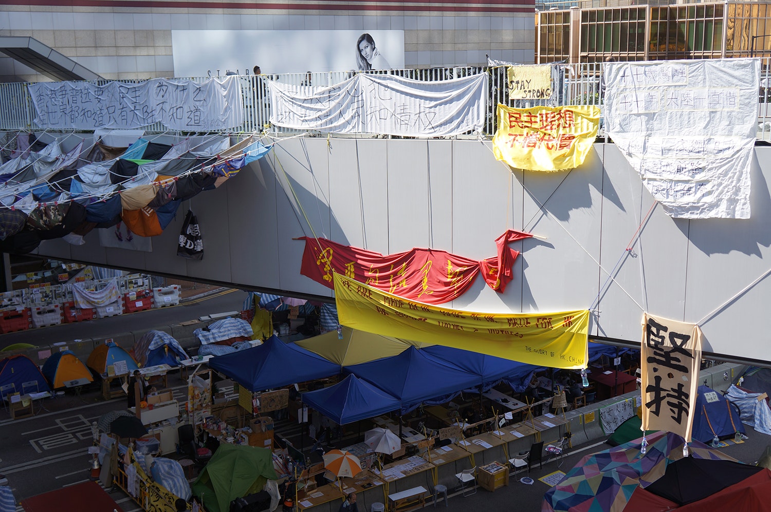 An overpass strung with banners handpainted with Chinese characters.