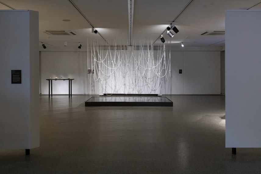 Ruth Ju-shih Li, Topography of Memory, 2021 – ongoing, unfired raw clay, porcelain and string, custom installation setting with black aluminium gloss floor plinth and ceiling mounting system; 3050mm x 1500mm, commissioned by 4A Centre for Contemporary Asian Art, 2021; photo: Rhiannon Hopley for Drawn by stones, presented by 4A Centre for Contemporary Asian Art at Gallery Lane Cove + Creative Studios, 2022, courtesy the artist.