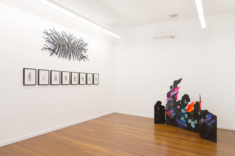 A white gallery space - on the left wall are eight drawings framed in black, hung under a mural composed of black lines resembling tree branches or veins. On the right is a five-panel plywood sculpture connected by metal hinges, painted black with neon and pastel clouds and flames