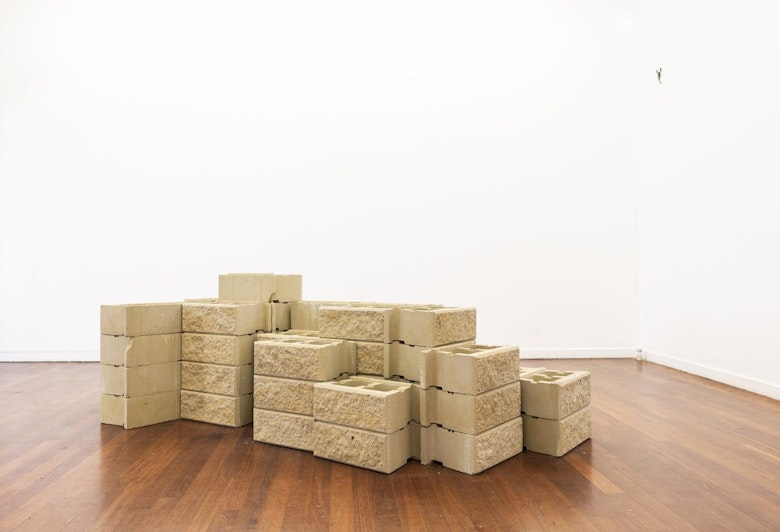 A mound of sandstone bricks on a hardwood floor.