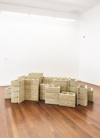 A mound of sandstone bricks on a hardwood floor.