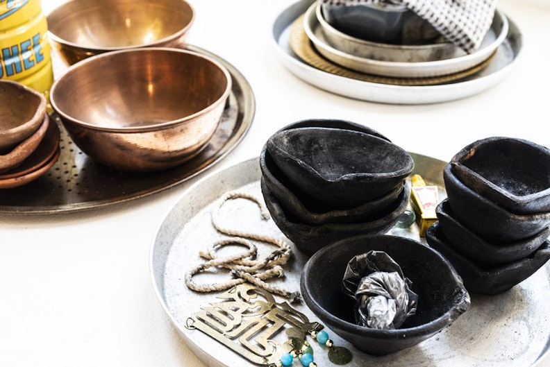 Close-up of black glazed clay bowls and brass bowls.