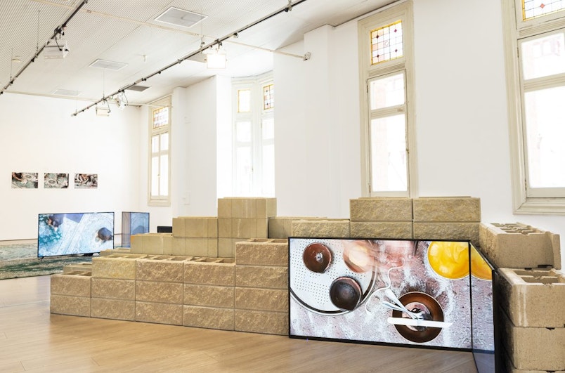 A TV screen showing hands moving over a platter with brass bowls.