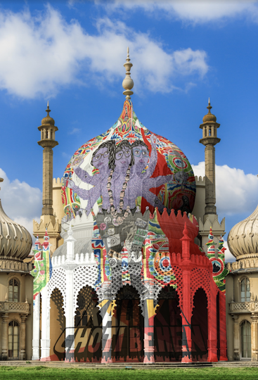 A daytime photo featuring the central dome of Brighton Pavillion (a building in the style of Indian architecture of the 19th century). On it warps a mural of a three-headed furry lilac desi-punk-dyke deity. Their similarly cropped and bespactled heads look up at two warped blue eyes gushing white tears and red blood against a bright, graphic design of birds and landscapes. A necklace of moustached heads swings over their three breasts, their desi-punk-patched black jeans and Doc Martens boots. Six arms hold black yarn, swiss army knife, tarot card, red dustpan, soup ladle, and book. They stand on a chunky title ‘Kali Ka Choti Behen’ with the rivers of tears and blood crossing over within the letters.