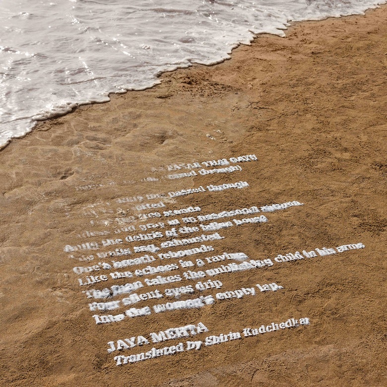 A poem written on sand using salt, the writing is partially eroded by lapping waves in the corner