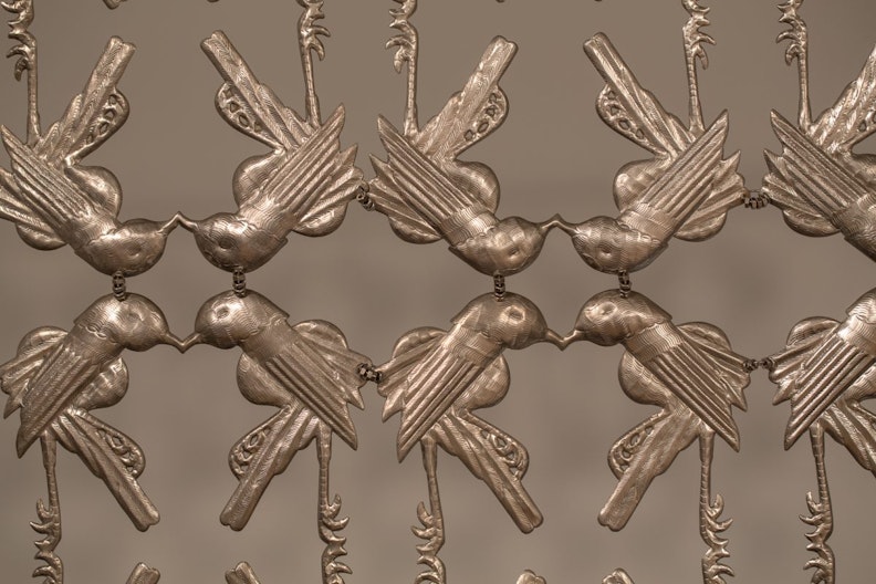 Close-up view of a sculpture made of intricate metal cutout shapes birds
