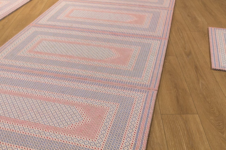 A close-up of prayer mats showing intricate geometric patterns