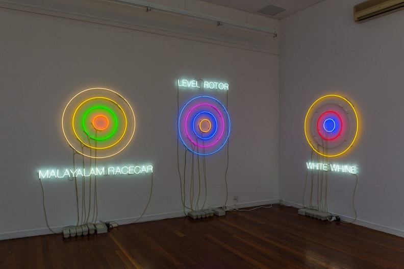 Neon lights in the shape of targets with text underneath or above