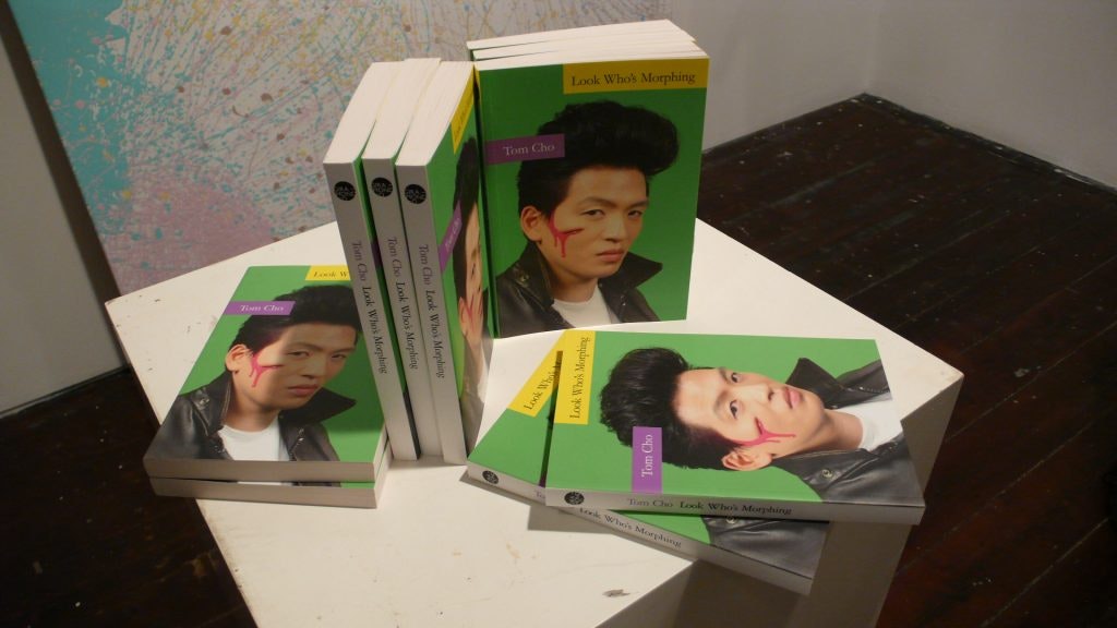 Copies of Tom Cho's book Look Who's Morphing stacked on a stand