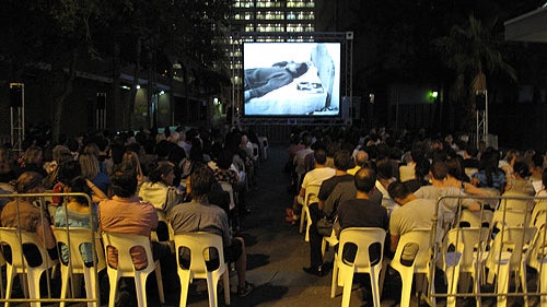 A photo of a seated audience at night watching a film as part of Cinema Alley 2012
