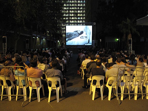A photo of a seated audience at night watching a film as part of Cinema Alley 2012