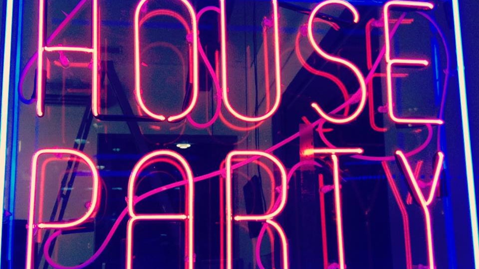 A neon sign with pink text reading house party and a blue border