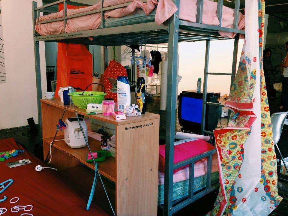 A photo from the Vertical Villages exhibition, showing a bunk bed, bedside table, and TV monitor