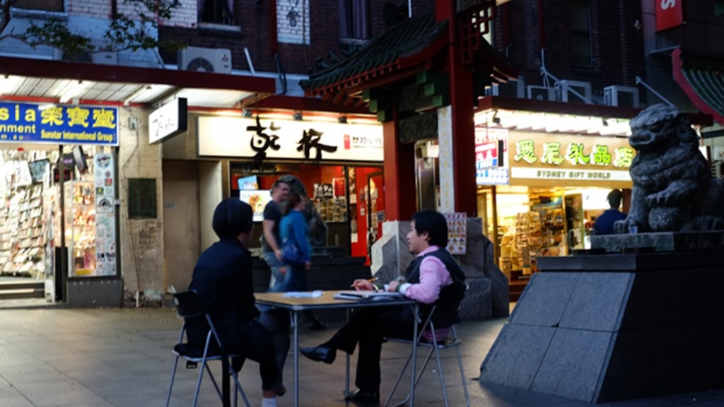 A photo of two people sitting at a table at the entrance to Dixon Street Mall