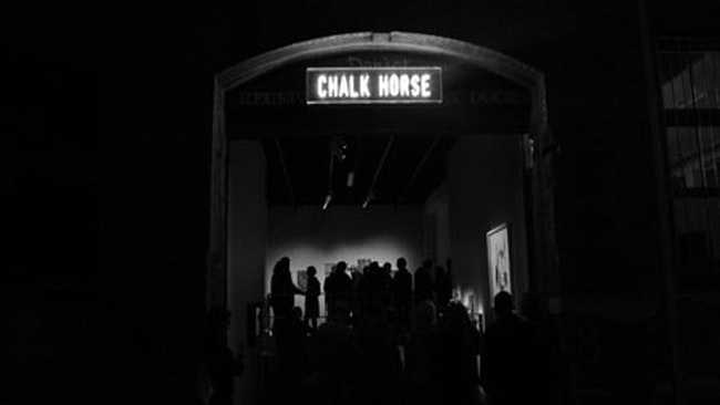A dark photograph showing people gathering at the contemporary art space Chalk Horse