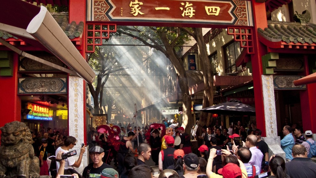 A photo of Dixon Street Mall, a large crowd takes photos of and watches a performance