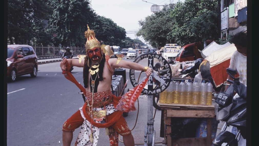Artist Adri Valery Wens dressed in a theatrical Hanoman costume on an Indonesian street