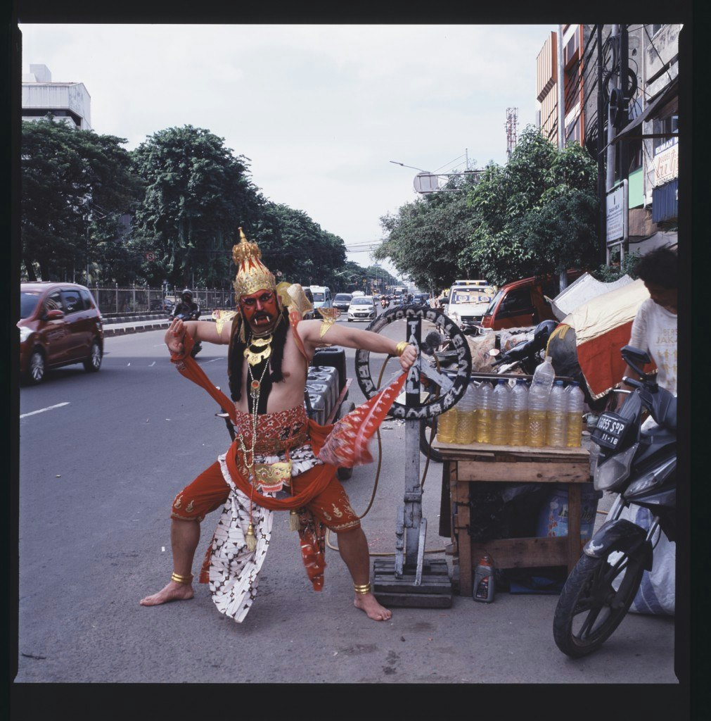 Artist Adri Valery Wens dressed in a theatrical Hanoman costume on an Indonesian street