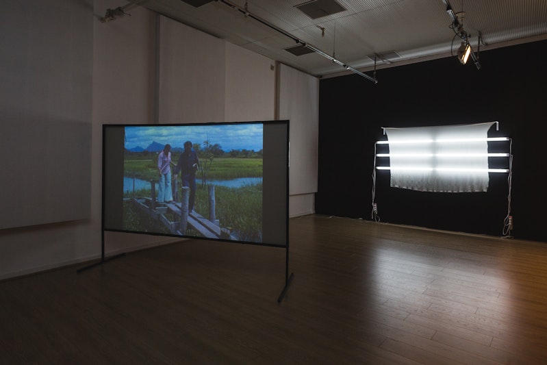 Left: Nathan Beard, Hiraeth (2015), single-channel HD video; installation view, 4A Centre for Contemporary Asian Art.  Right: Andy Mullens, Still (2015), silk, fluorescent lights, metallic thread; installation view, 4A Centre for Contemporary Asian Art. Courtesy the artists. Image: Document Photography.