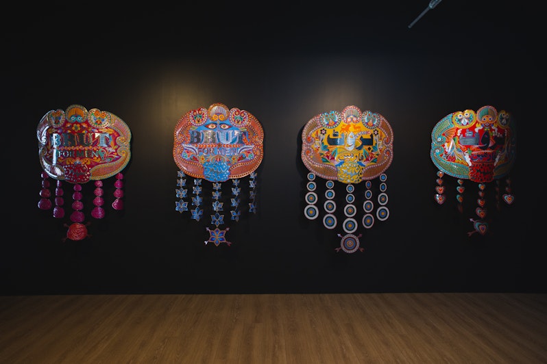 Abdullah M.I. Syed, Brut for Men series (2013), hand-beaten metal medallion and chamak patti (hand-made sticker ornamentation), wood, stainless steel; installation view, 4A Centre for Contemporary Asian Art. Courtesy the artist. Image: Document Photography.