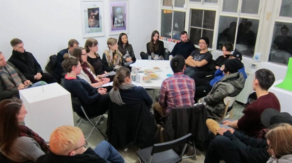 A group of people sitting around a table in discussion