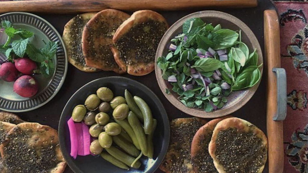 A traditional Lebanese breakfast of za’atar manoosheh, labneh and olives on a breakfast board.