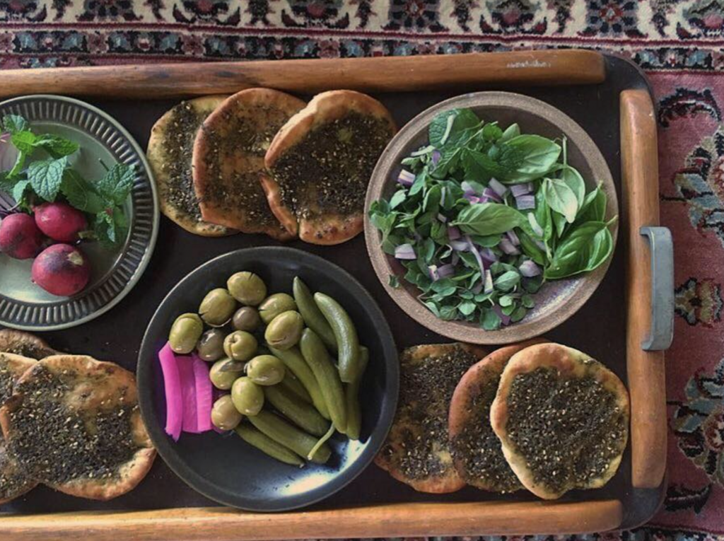 A traditional Lebanese breakfast of za’atar manoosheh, labneh and olives on a breakfast board.