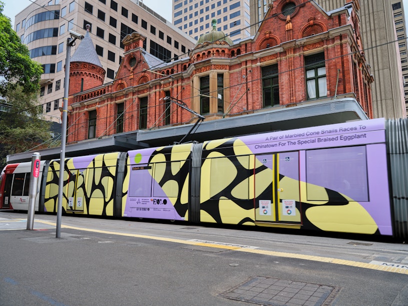 Evi O, A Pair of Marbled Cone Snails Races to Chinatown for The Special Braised Eggplant, 2023, light rail wrap. A Pair of Marbled Cone Snails Races to Chinatown for The Special Braised Eggplant is supported by The City of Sydney's Precinct Activation Grant Program. Image: Andrew Grune