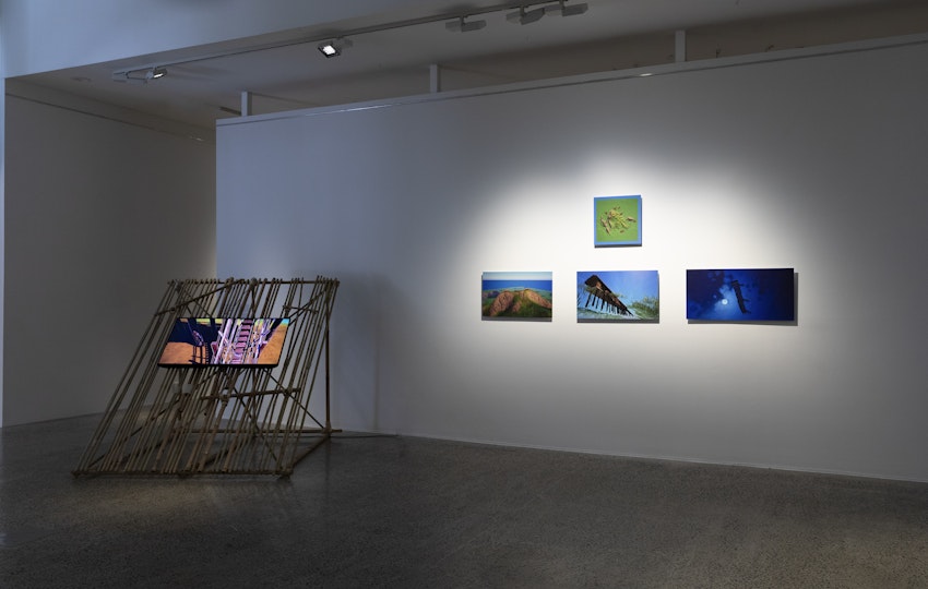 Tiyan Baker, Building a longhouse at the site of the first Bukar Bidayǔh settlement, 2025, digital video, sound, bamboo, nuts, bolts, sisal rope, wire; Tiyan Baker, Top view of Bung Sadung and surrounding villages, 2025, digital print mounted on dibond; Tiyan Baker, Ancestral longhouse - view from inside topography at night, 2025, digital print mounted on dibond; Tiyan Baker, Ancestral longhouse - view from inside topography at midday, 2025, digital print mounted on dibond; Tiyan Baker, Ancestral longhouse - birds eye view in the morning, 2025, digital print mounted on dibond. All works courtesy of the artist.