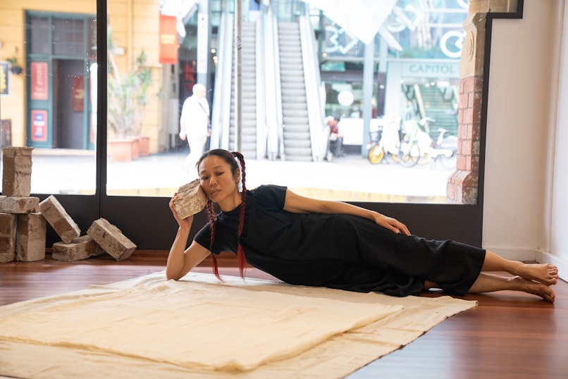 Weizen Ho, material : brick ~ material : body (performance view), 2026. Photograph by Christina Mishell.