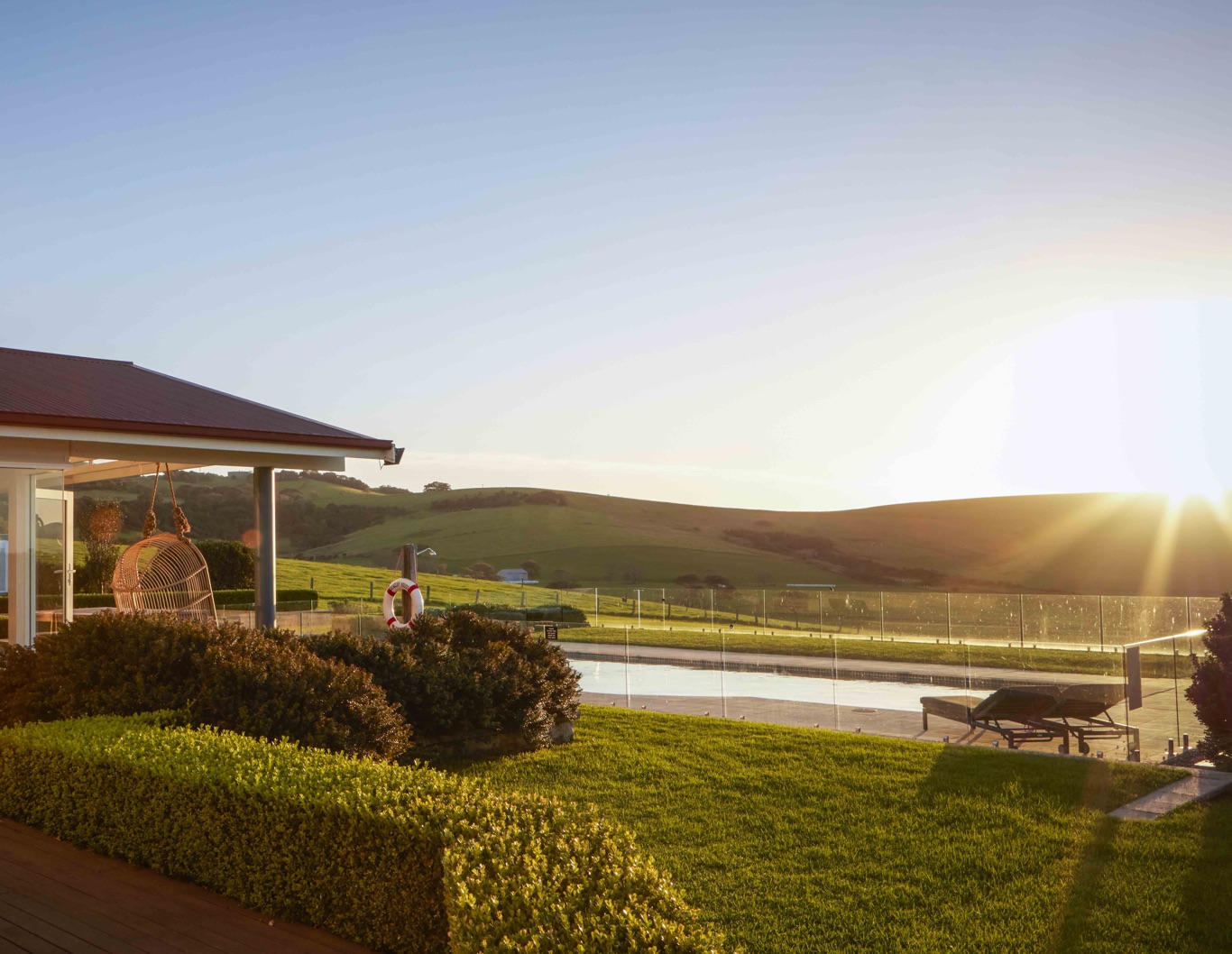 Seacliff House accommodation with sunlight over swimming pool.