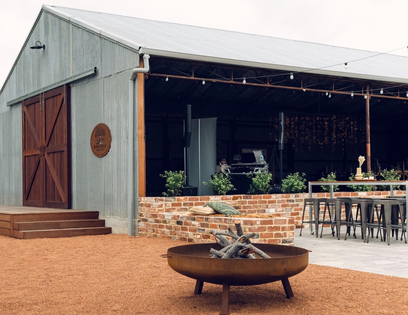 Modern farm barn, with firepit and outdoor table arrangement.