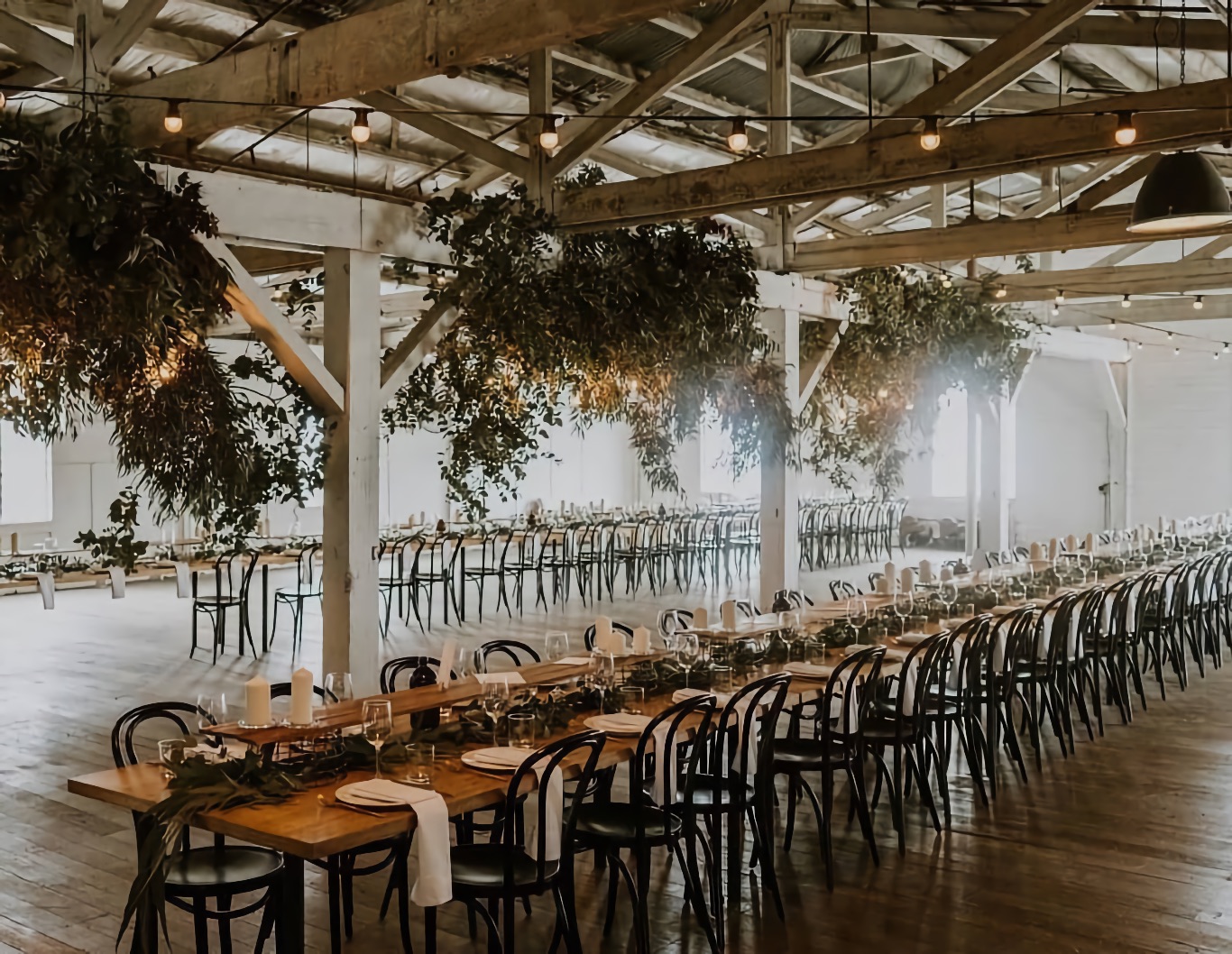 Wedding tables set in a warehouse space.